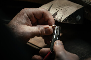 Jeweler making handmade jewelry on vintage bench. The art of jewelry.