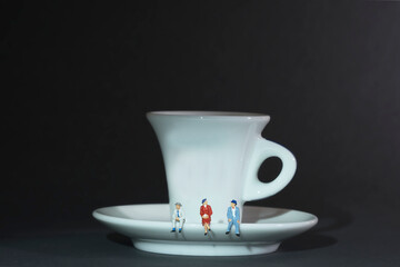 Photography of miniature people and toy figures, a group of people sitting on a coffee cup for a break, dark background