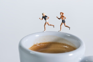 Photography of miniature people and toy figures, joggers on a white cup of coffee, morning exercise