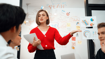 Young beautiful caucasian businesswoman presenting marketing strategy by using mind map, graph...
