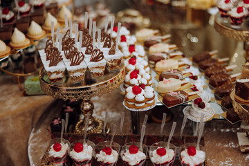 Almond cookies, sweet cakes for a wedding banquet. A delicious reception, a luxurious ceremony. Table with sweets and desserts. Delicious colorful French desserts on a plate or table. Candy bar.