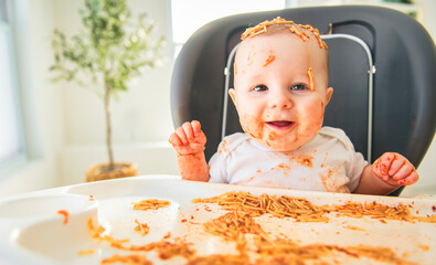 Little baby eating her dinner and making a mess