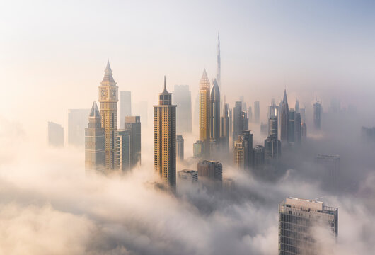 Aerial view of Burj Khalifa and Downtown Dubai surrounded by hazy clouds, Dubai, United Arab Emirates.