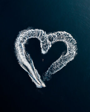 Aerial view of person in the water with a motorboat doing a heart shaped manouvre in the open sea, Primorje-Gorski Kotar, Croatia.