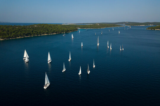 Aerial view of sailing boats for a regatta along the coastline in Zara with beautiful Adriatic coastline and turquoise sea, Croatia.