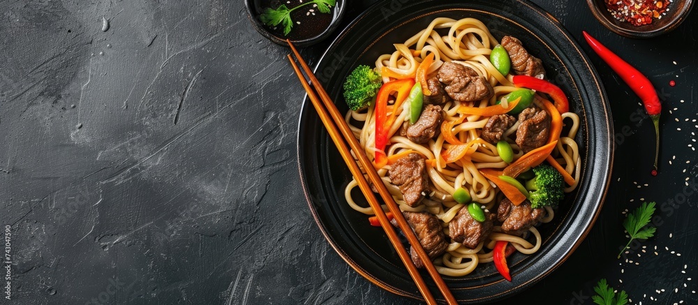 Poster chinese udon noodles with stir fried veal and vegetables served on plate. with copy space image. pla