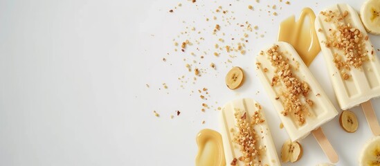 Peanut butter banana popsicles with sprinkles of peanuts and drizzle of raw peanut butter on top above view. with copy space image. Place for adding text or design - obrazy, fototapety, plakaty