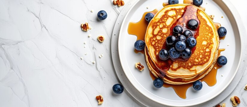 Crepes or blinis or thin pancakes with blueberries hazelnuts and chocolate sauce on a white plate at white stone table Maslenitsa traditional Russian festival meal. with copy space image