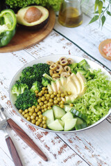 A bowl with a salad made of green vegetables