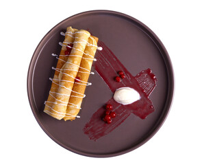 Pancakes (crepes) with sweet filling and berry sauce on a round dark plate. Top view. On a transparent background