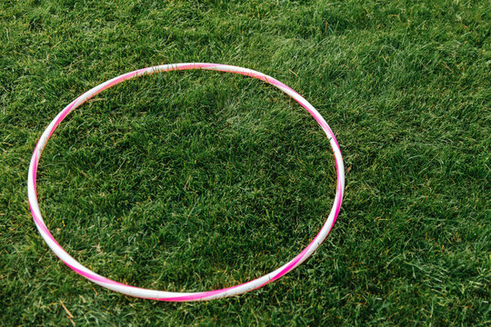 leisure games and sports equipment concept - close up of hula hoop on grass