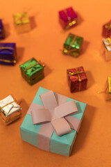 Christmas and New Year Concept: Gift Box with Bow on Vibrant Orange Background