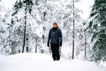 Hiker walking in winter landscape during snowfall