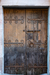 Detail of old wooden door with ornate hinges and wrought iron lock in the French village of Villefranche de Conflent.