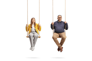 Teenage girl and a mature man sitting on wooden swings