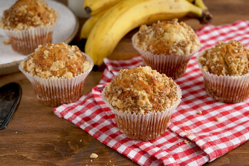 delicious banana muffins on red napkin on wooden table