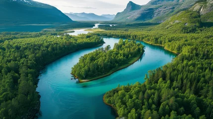 Abwaschbare Fototapete Aerial View of a Serpentine Turquoise River Flowing Through Pine Forests with Mountain Peaks in the Background, Innlandet County, Norway © bomoge.pl