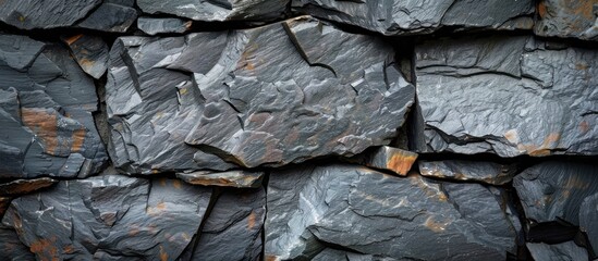 A heap of dark grey black rocks covered in rust, creating a rugged and weathered appearance.