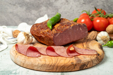 Smoked cold beef sirloin and slices on cutting board. Cold roastbeef slices on gray background. Close up