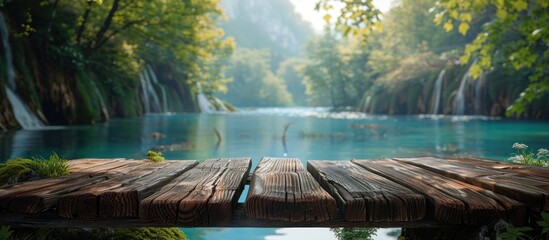 A wooden dock stretches out over a river, providing a platform for boats and water activities. The tranquil scene captures the essence of a peaceful day by the water. - obrazy, fototapety, plakaty