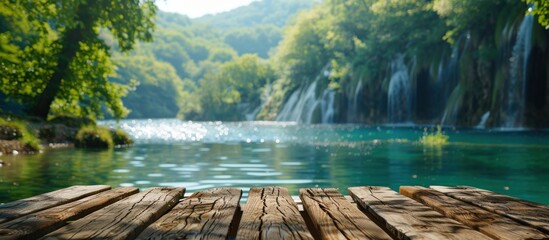 A wooden dock extending into the water with a majestic waterfall in the background.