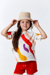 Portrait of cute kid girl model in straw hat arm touch standing on white background