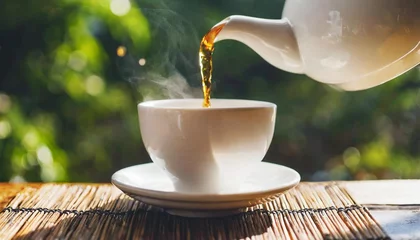 Foto op Plexiglas close up pouring hot black tea in a white tea cup tea ceremony time concept © Patti