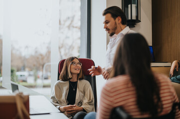 Focused team members engage in a lively discussion with a male colleague addressing the group in a...