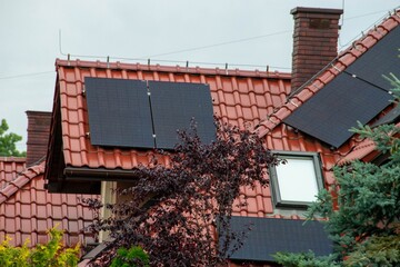 Historic farm house with modern solar panels on roof and wall
