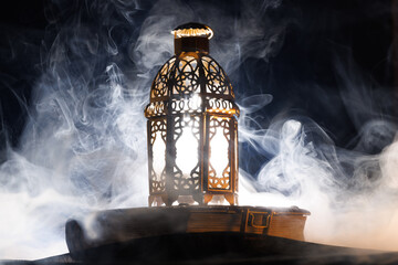 Ornamental Arabic lantern with burning candle glowing at night.Festive greeting card, invitation...