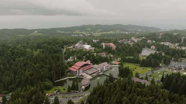 Capturing aerial footage with a drone of an indescribable landscape in the mountains with guesthouses and vacation homes nestled among the forests below