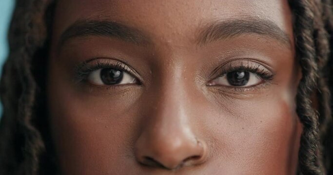 Woman, focus and face with closeup of eyes for optometry, glaucoma exam and optical assessment in studio. Ophthalmology, person and portrait for eyecare, eyesight and wellness on blue background