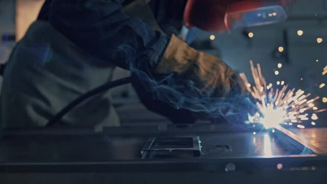 Welder's work with lots of sparks and smoke close-up in slow motion 