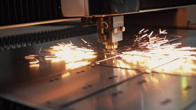 Sparks flying in slow motion from the operation of a CNC plasma cutting machine on sheet steel. Close-up 