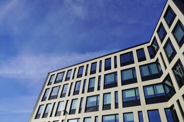 Look up to white building facade towards blue sky. Kopli, Tallinn, Estonia. February 2024