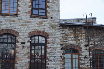 Fototapeta na wymiar A brick building with a lot of windows and a fire escape