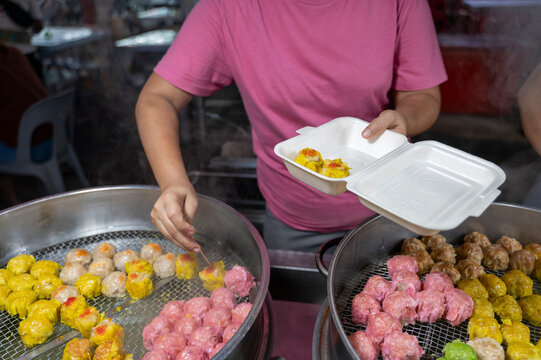 Anonymous malaysian woman cooking street colorful dim sum food