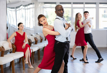 Energy African American man and woman are dancing classic version of waltz in couple during lesson...