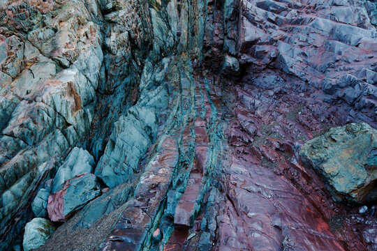 Colorful biofilm bacteria on iron-rich beach rocks