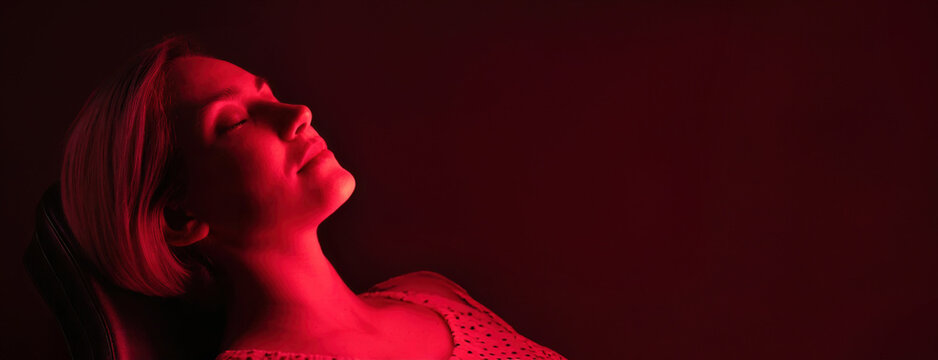 Woman relaxing in red ambient light. The calming illumination envelops female in a tranquil atmosphere, suggesting relaxation and serenity