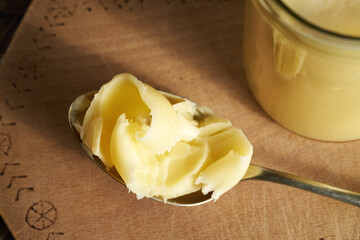 Ghee or clarified butter on a spoon and in a jar