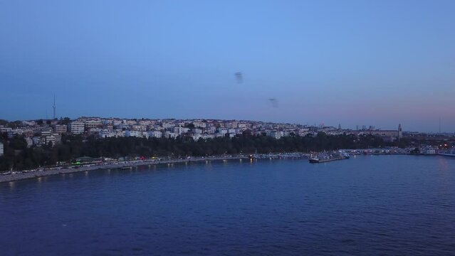 Aerial overflight: Uskudar District in Istanbul at night. Aerial shot of the city over the sea
