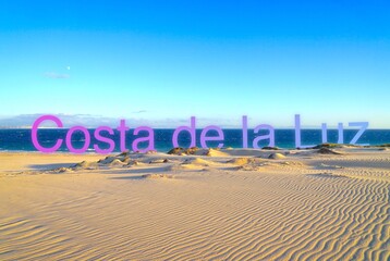 blue Costa de la Luz Lettering with purple gradient in the wonderful dune landscape at the Atlantic...