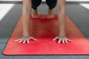 Young woman practicing yoga, doing Push ups or press ups exercise, phalankasana Plank pose, working...