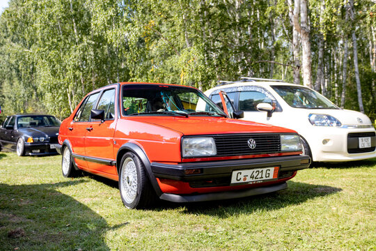 car on a green grass red Volkswagen Jetta