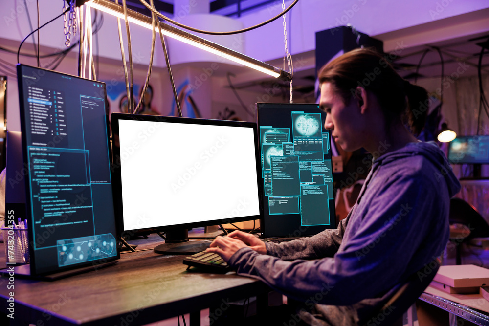Poster scammer hacking using computer with empty white screen in abandoned warehouse. asian criminal coding
