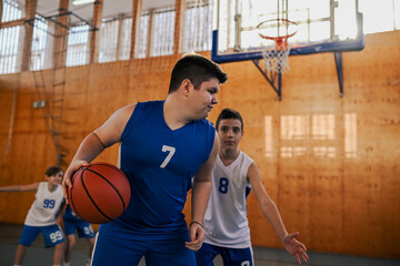 Active junior basketball player in action guarding a ball during game.