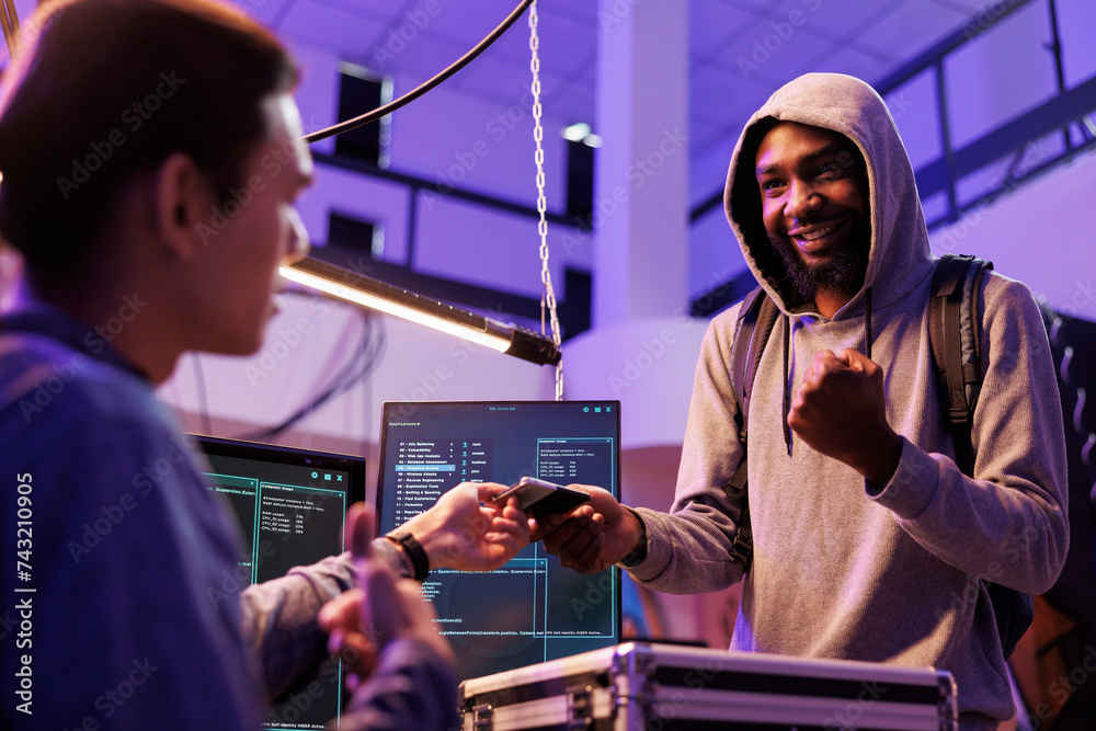 Poster smiling cheerful illegal malware developer holding ssd with computer virus. happy hacker giving hard