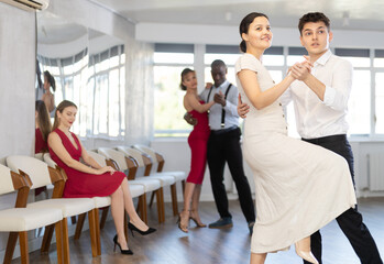 During rehearsal of reporting concert, man and Asian woman participants of dance workshop perform...