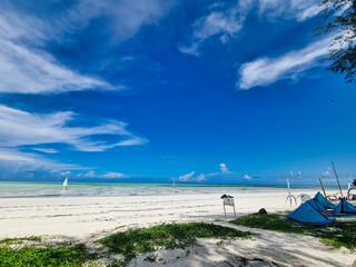 Zanzibar beach with wooden sailboat under blue sky Sun